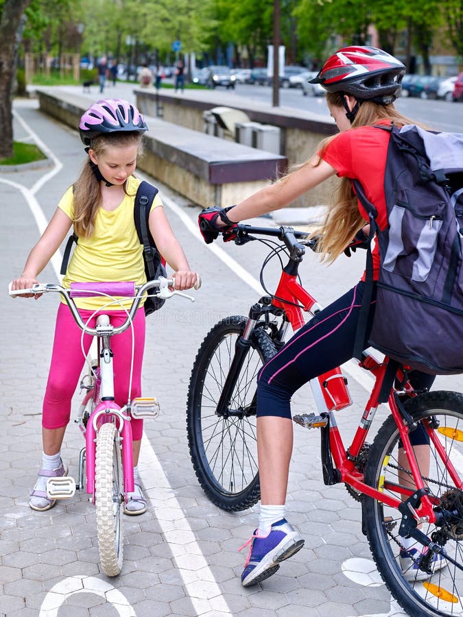 Girls children cycling on yellow bike lane. stock photo Girls children cycling on yellow bike lane. stock photo