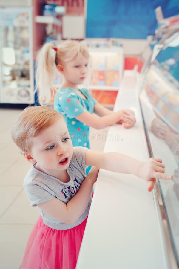 Girls children sisters friends looking at ice cream shop window royalty free stock photography Girls children sisters friends looking at ice cream shop window royalty free stock photography