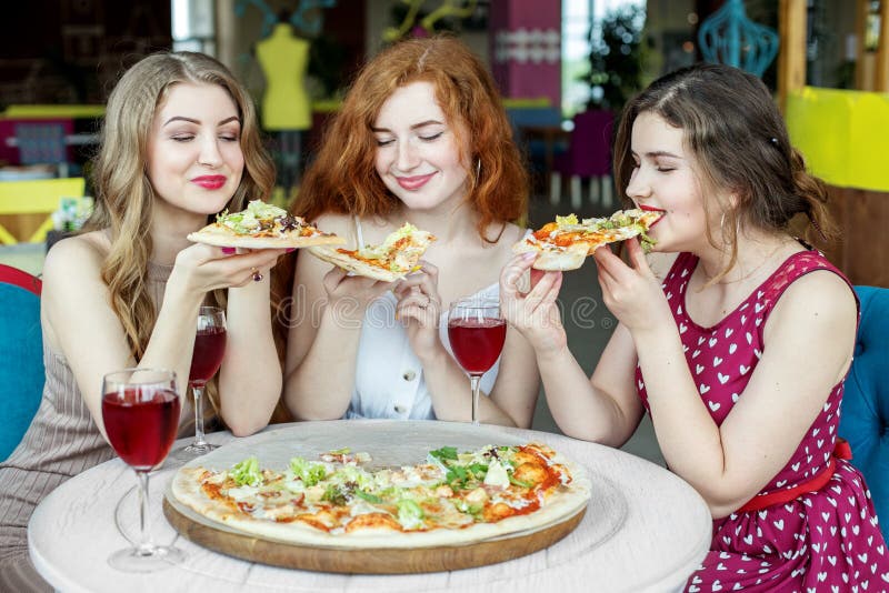 Girls eat pizza. The concept of food and alcohol, fast food, lifestyle stock image Girls eat pizza. The concept of food and alcohol, fast food, lifestyle stock image
