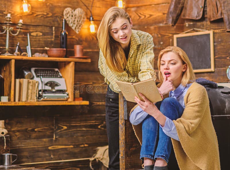 Girls excited about new novel by favorite writer, literature concept. Family evening in countryside wooden cottage. Bookworms, mother and daughter, reading interesting book in living room.