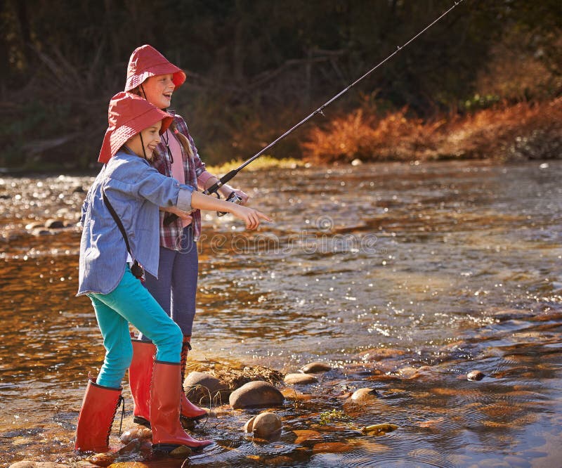 Girls Gone Fishing. Two Young Girls Fishing by a River. Stock