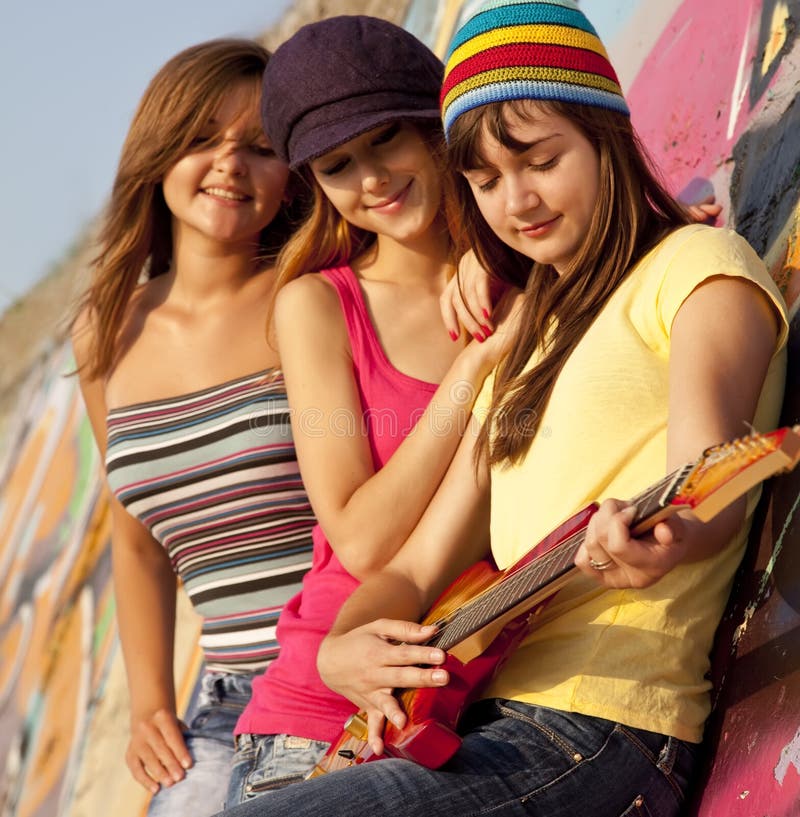 Girls with guitar and graffiti wall