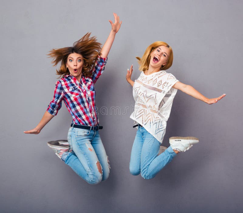 Girls jumping over gray background stock photos Girls jumping over gray background stock photos
