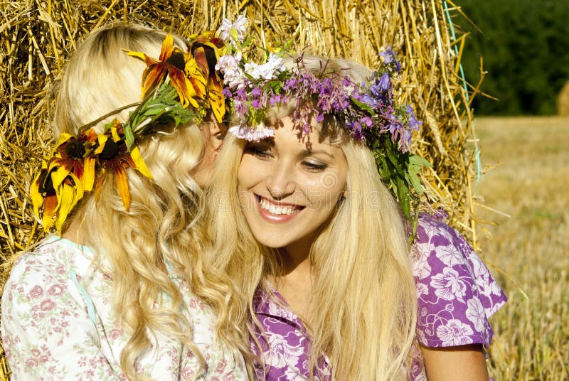 Girls near haystacks with wreaths on their heads