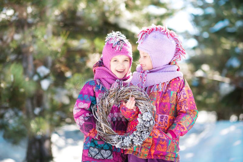 Girls in pink suits hold a Christmas wreath in winter. Children`s winter holidays stock images Girls in pink suits hold a Christmas wreath in winter. Children`s winter holidays stock images