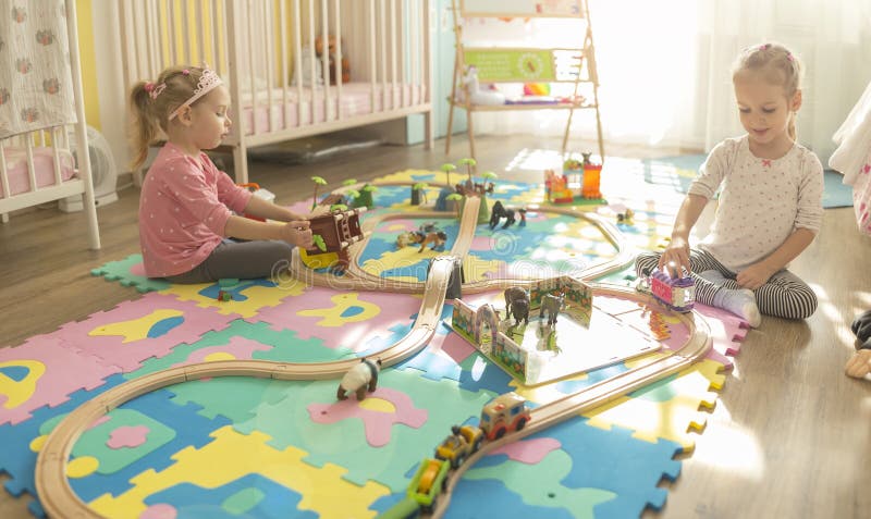 Girls play with a wooden set