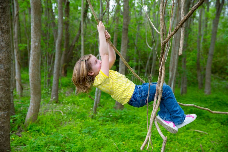 Deti, dievčatá hrajú zavesenie a lezenie z lianas v džungli forest park vonku.
