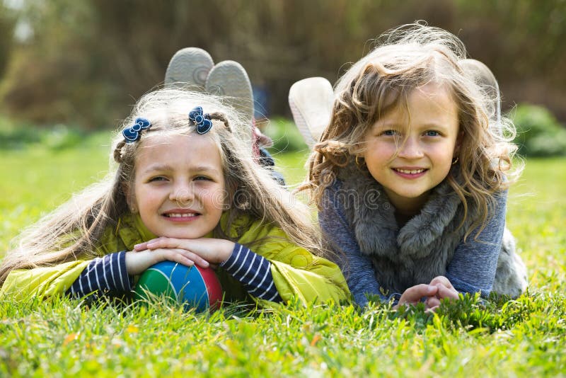 Girls relaxing in grass stock photo. Image of friendship - 72064454