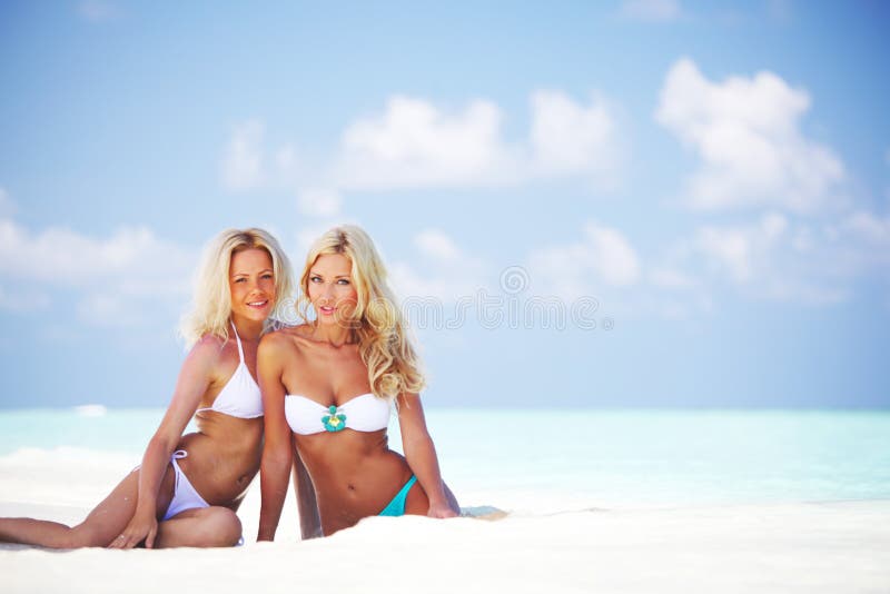 Girls sitting on ocean coast