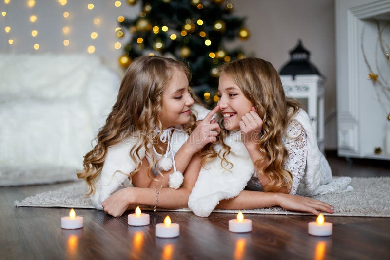 Girls twins in front of the fur-tree royalty free stock photography Girls twins in front of the fur-tree royalty free stock photography