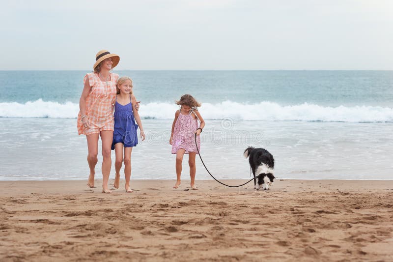2 girls walking on beach with mom and dog. Happy family walking. stock photography 2 girls walking on beach with mom and dog. Happy family walking. stock photography