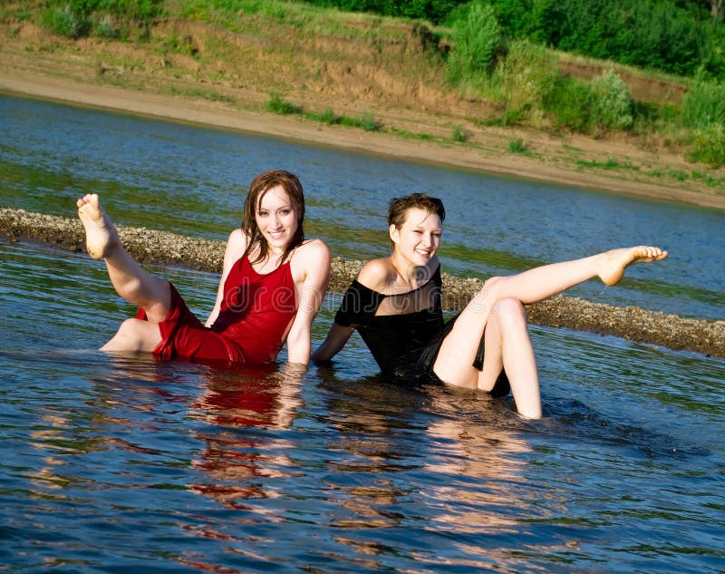 Girls in wet dress sits in water