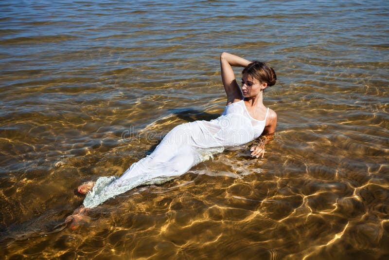 Girls in white dress lying in water