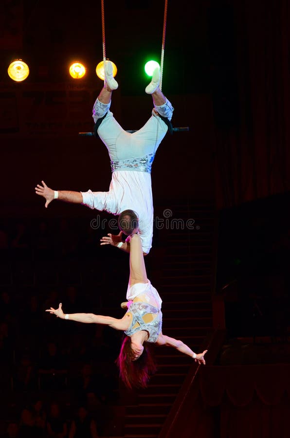 GOMEL, BELARUS - MARCH 23, 2018: Tour of Moscow State Circus named after Nikulin. Duet on trapeze air gymnasts Victoria and Alexei Artemyev. GOMEL, BELARUS - MARCH 23, 2018: Tour of Moscow State Circus named after Nikulin. Duet on trapeze air gymnasts Victoria and Alexei Artemyev