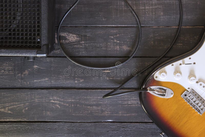 Gitara elektryczna i czarny amplifikator łączyliśmy kablem na drewnianym fotografia stock Gitara elektryczna i czarny amplifikator łączyliśmy kablem na drewnianym fotografia stock
