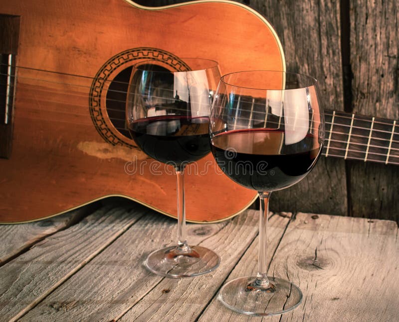 Gitarr och vin på en trätabellromantikermatställe arkivfoto Gitarr och vin på en trätabellromantikermatställe arkivfoto