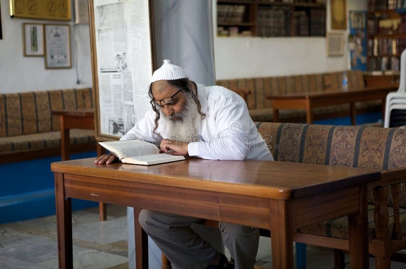 Jewish orthodox man is reading hebrew text in the Abuhav synagogue in Safed, Israel. Since the 16th century, Safed has been considered one of Judaism's Four Holy Cities, along with Jerusalem, Hebron and Tiberias. Jewish orthodox man is reading hebrew text in the Abuhav synagogue in Safed, Israel. Since the 16th century, Safed has been considered one of Judaism's Four Holy Cities, along with Jerusalem, Hebron and Tiberias