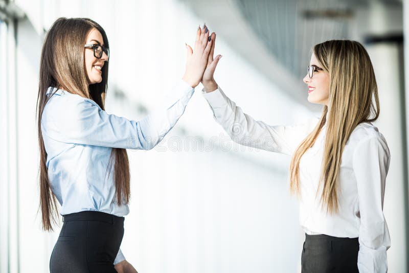 Give Me High five Two Business Women Give High Five In Modern Office Give Me High five Two Business Women Give High Five In Modern Office