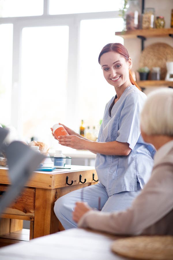 Caregiver Wearing Uniform And Sneakers Visiting Pensioner Stock Image Image Of Redhaired