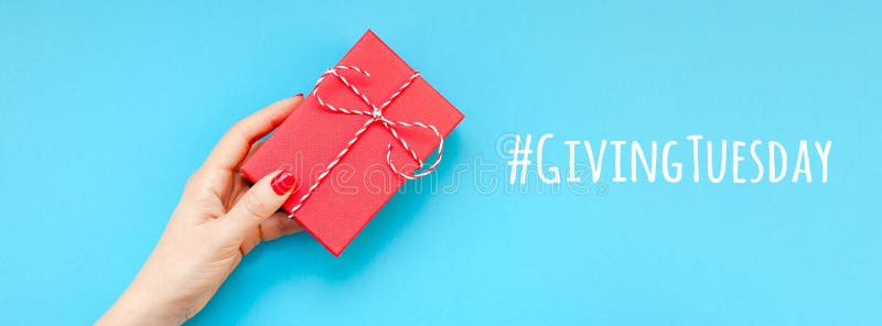 Giving Tuesday is a global day of charitable giving after Black Friday shopping day. Charity, give help, donations and support concept with text message sign and woman hand holding red gift box. Giving Tuesday is a global day of charitable giving after Black Friday shopping day. Charity, give help, donations and support concept with text message sign and woman hand holding red gift box