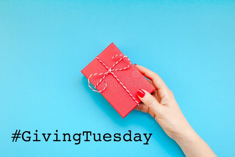 Giving Tuesday is a global day of charitable giving after Black Friday shopping day. Charity, give help, donations and support concept with text message sign and woman hand holding red gift box. Giving Tuesday is a global day of charitable giving after Black Friday shopping day. Charity, give help, donations and support concept with text message sign and woman hand holding red gift box