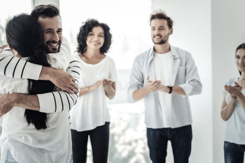 Nice delighted man hugging his friend stock image Nice delighted man hugging his friend stock image