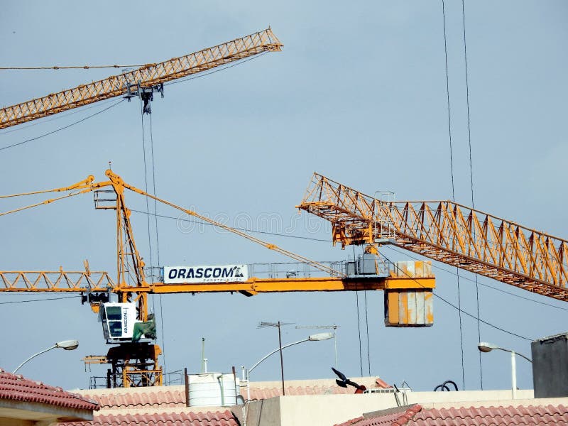 Giza, Egypt, March 28 2021: crane towers at a construction site of new high rise developmental residential buildings in Sheikh Zayed city, selective focus of cranes for new city building. Giza, Egypt, March 28 2021: crane towers at a construction site of new high rise developmental residential buildings in Sheikh Zayed city, selective focus of cranes for new city building