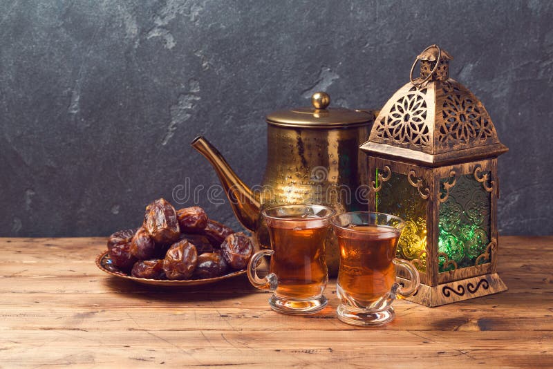Gjorda ljusare lykta, tekoppar och data på trätabellen över svart tavlabakgrund Beröm för Ramadankareemferie royaltyfri bild