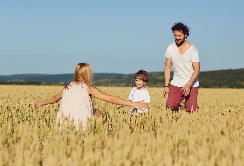Gl?ckliche Familie, die den Spa? spielt auf dem Gebiet hat lizenzfreie stockbilder Gl?ckliche Familie, die den Spa? spielt auf dem Gebiet hat lizenzfreie stockbilder