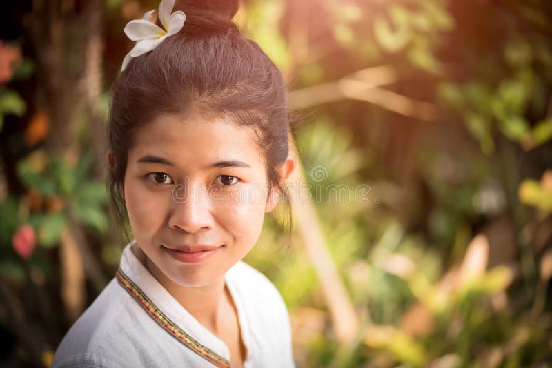 Gl?ckliche junge asiatische Frauenholdingorchidee mit einem gl?cklichen L?cheln graden herein stockfoto Gl?ckliche junge asiatische Frauenholdingorchidee mit einem gl?cklichen L?cheln graden herein stockfoto