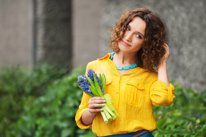 Gl?ckliche junge Modefrau im gelben Hemd mit Blumenstrau? von Blumen lizenzfreie stockbilder Gl?ckliche junge Modefrau im gelben Hemd mit Blumenstrau? von Blumen lizenzfreie stockbilder