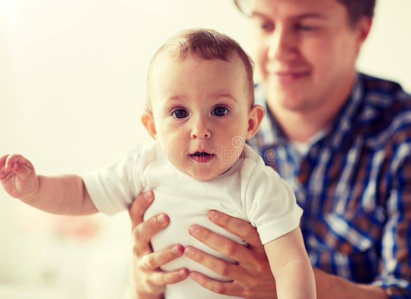 Gl?cklicher junger Vater mit kleinem Baby zu Hause lizenzfreies stockbild Gl?cklicher junger Vater mit kleinem Baby zu Hause lizenzfreies stockbild