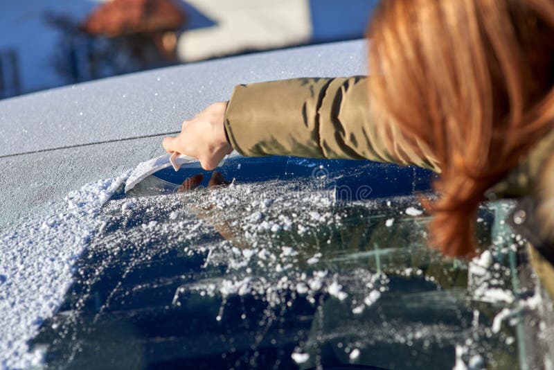 Winter driving - scraping ice from a windshield. Winter driving - scraping ice from a windshield