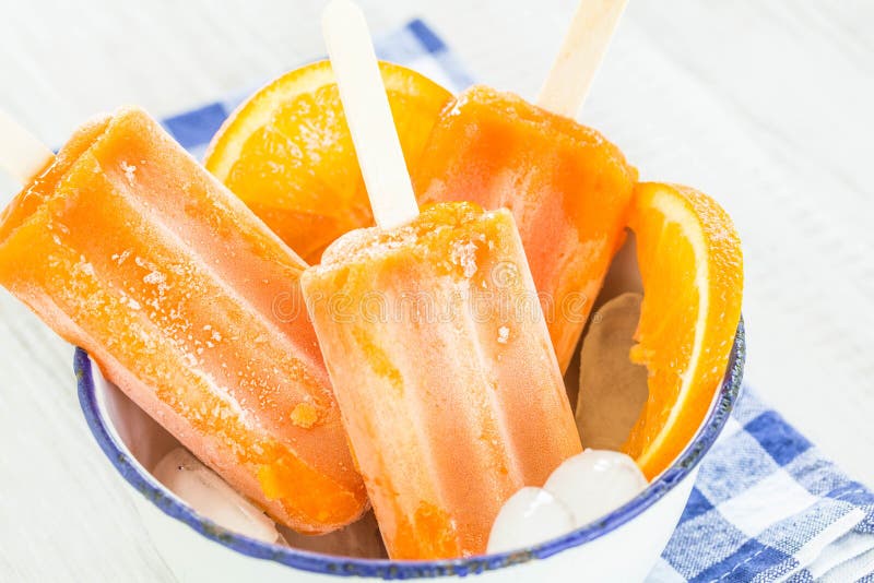 Glaces à l'eau et tranches oranges de fruit dans la cuvette de glace photo stock Glaces à l'eau et tranches oranges de fruit dans la cuvette de glace photo stock