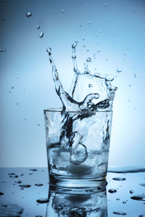Glacez l'éclaboussement dans un verre frais de l'eau photographie stock Glacez l'éclaboussement dans un verre frais de l'eau photographie stock
