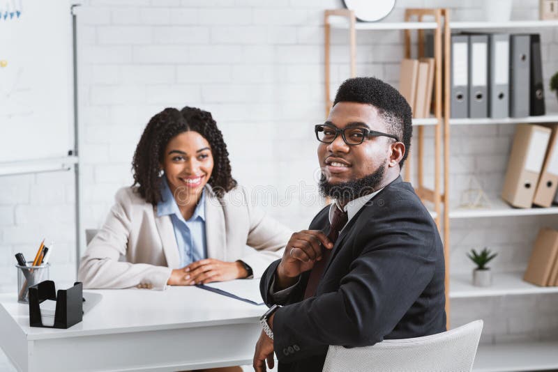 Joyful African American guy having job interview with hiring manager at company office. Joyful African American guy having job interview with hiring manager at company office