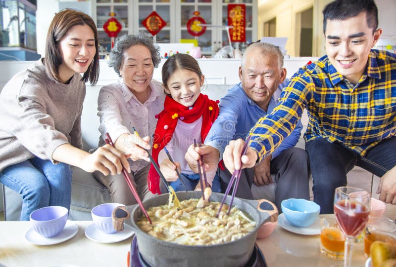 Glad asiansk familj som äter middag och firar kinesiska nya år hemma royaltyfria bilder