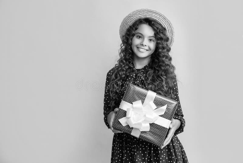 Glad Child with Curly Hair Hold Present Box on Blue Background Stock