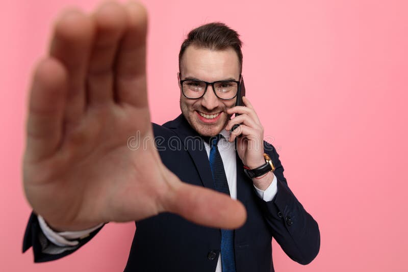 Glad elegant man i kostym som pratar i telefon och raming arkivbild