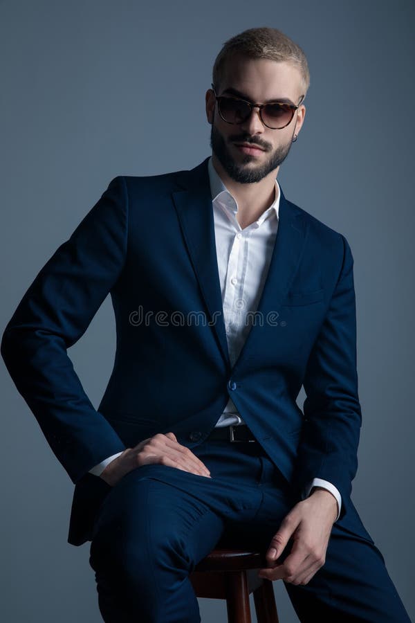 Glad elegant man i marindräkt, sits och sjömil royaltyfria bilder