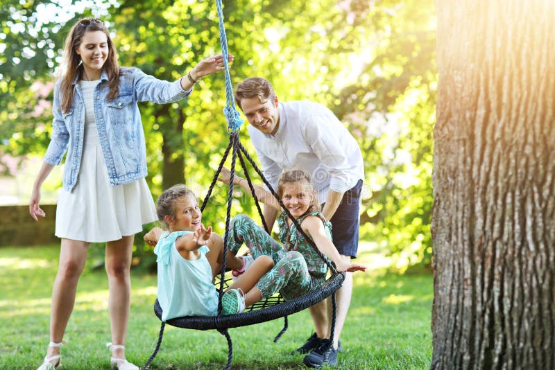 Glad familj som har gyckel på lekplats royaltyfri fotografi Glad familj som har gyckel på lekplats royaltyfri fotografi