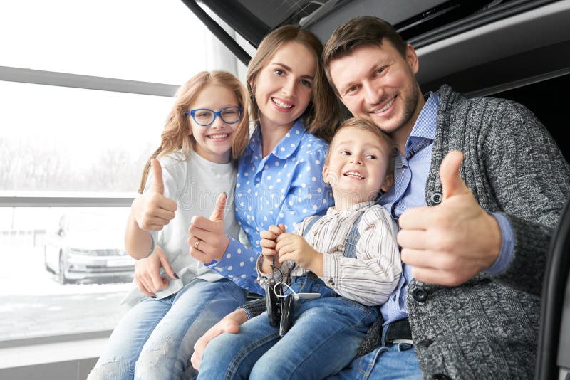 Glad familj som visar skylten OK i automatisk salong fotografering för bildbyråer Glad familj som visar skylten OK i automatisk salong fotografering för bildbyråer