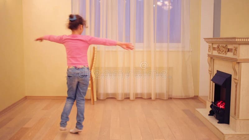 Glad flicka i jeans dans i nytt rum med arkivfilmer