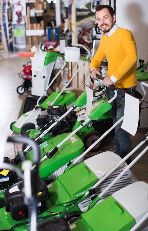 Glad Guy Deciding On Best Lawnmower In Garden Equipment Shop Stock