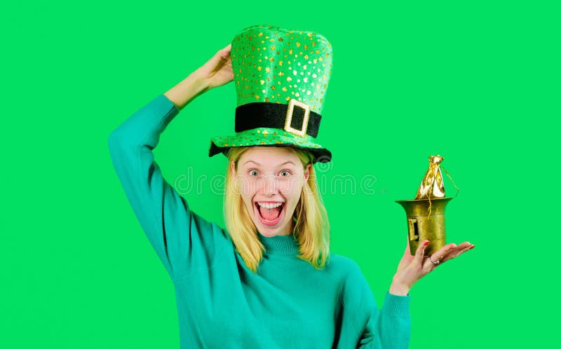 Glad kvinna i grön topphatt med liten påse guld. festdagar. Pengar för patricks-festen royaltyfria bilder