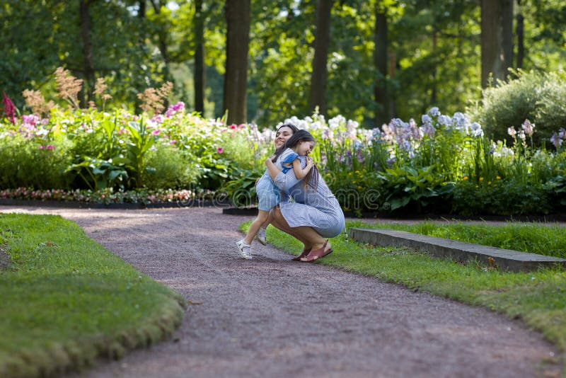 Glad mor som går med dotter i parkering utomhus fotografering för bildbyråer Glad mor som går med dotter i parkering utomhus fotografering för bildbyråer