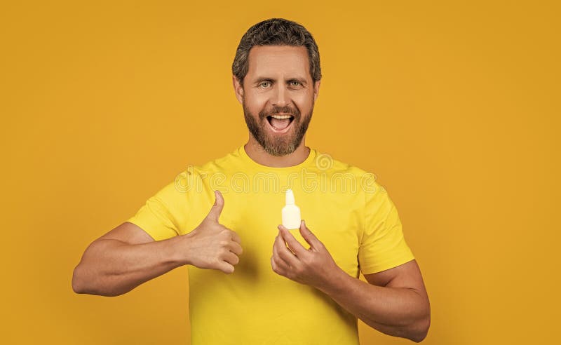 glad healthcare man with medicine on background. healthcare man with medicine in studio. photo of healthcare man with medicine drops. healthcare man with medicine isolated on yellow. glad healthcare man with medicine on background. healthcare man with medicine in studio. photo of healthcare man with medicine drops. healthcare man with medicine isolated on yellow.