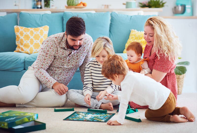 Happy young family playing board games together at home. Happy young family playing board games together at home