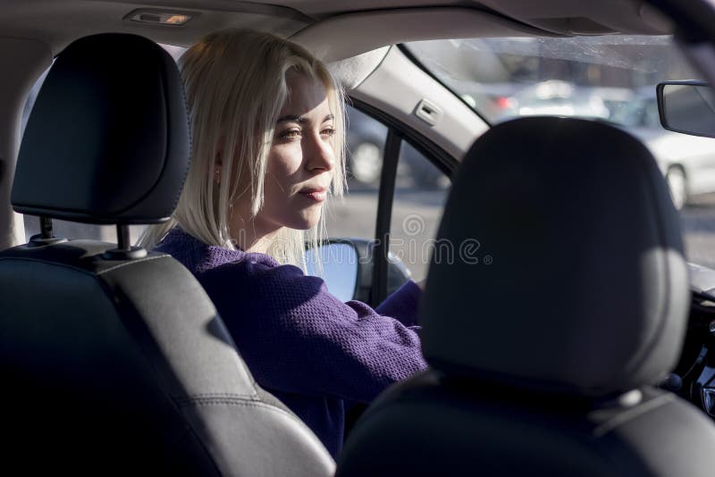 Glad söt caucasian brunette som kör bil. foto taget från baksätet royaltyfri foto