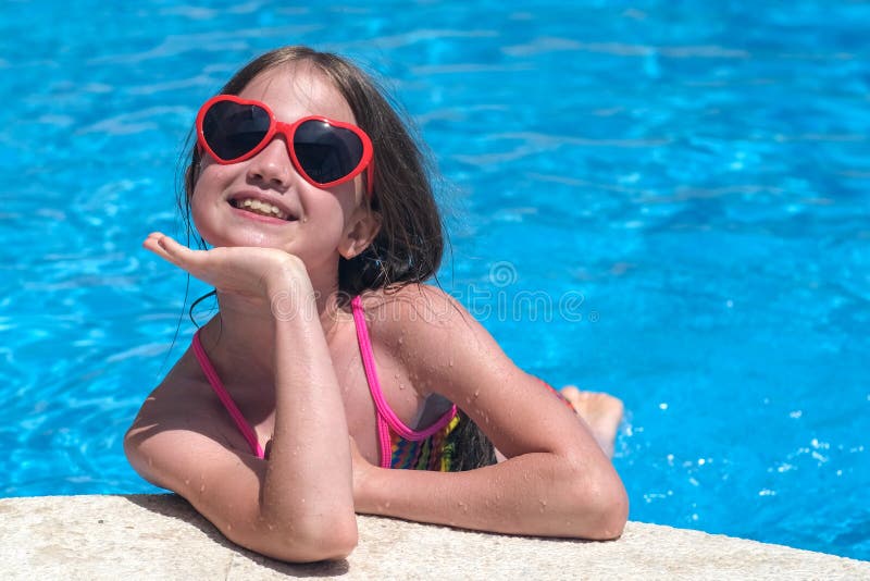 Glad unge i solglasögon i poolen på soldagen. Barnvärdesdag och sommarledighetskoncept royaltyfria foton